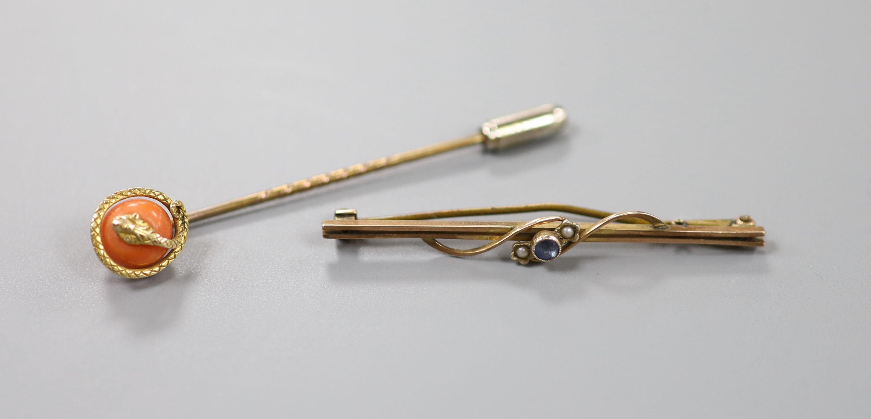 A gilt metal stick pin set with yellow metal serpent entwined coral bead, 60mm and a 9ct, sapphire and seed pearl set bar brooch, gross 2.4 grams.